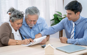Asian senior couple making sign contract to buy new house.